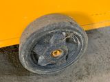 a close up of a wheel on the side of a yellow bus