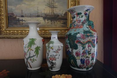 trois vases posés sur une table à côté d'un tableau