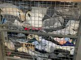 many stuffed animals in a cage on a cart
