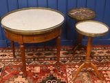 two tables with marble tops sit on a rug in front of a blue wall