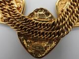 a close up of a gold necklace on a white surface