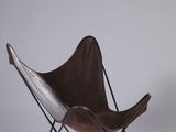 fauteuil papillon en cuir avec des pieds en métal noir et une assise en cuir marron