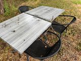 a table with two chairs and a table top that has a broken piece of wood on it