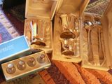 a box of silverware sitting on the floor next to a pair of spoons and spoons