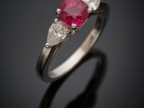Gros plan sur une bague sertie d'un rubis et de diamants, posée sur une surface noire
