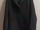 a picture of a black coat hanging on a wall