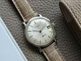 a watch sitting on top of a brown leather bag
