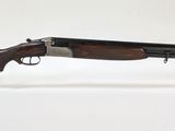 un vieux fusil de chasse au canon en bois, posé sur un socle en acrylique transparent