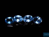 un ensemble de trois saphirs bleus posés sur une surface noire