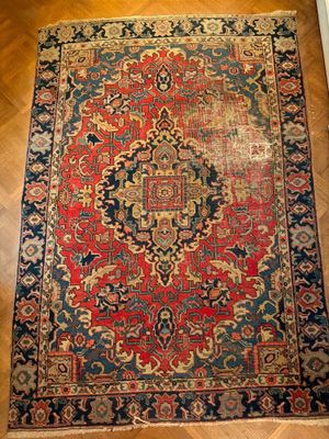 un tapis oriental rouge et bleu posé sur un parquet