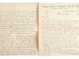 un vieux livre sur lequel est posée une lettre manuscrite, posé sur une table