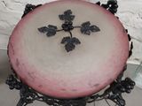 a pink and white cake with black decorations on it