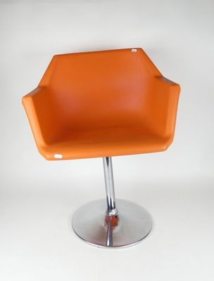 une chaise orange avec un piètement chromé sur fond blanc