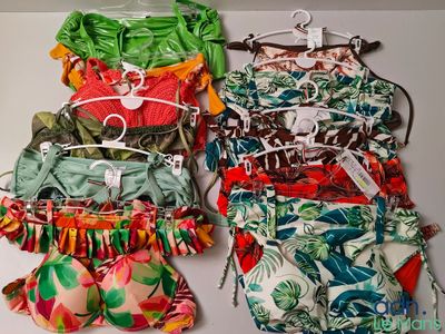trois maillots de bain suspendus à un cintre accroché au mur