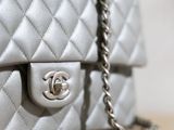 a close up of a silver chanel bag on a table