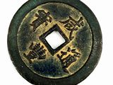 an old chinese coin with chinese writing on it on a white surface