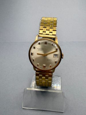 an image of a gold wrist watch on a clear stand
