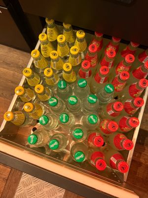 de nombreuses bouteilles de soda posées dans un tiroir posé à même le sol