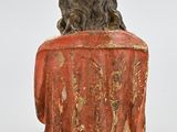 an old statue of a man with a beard and a red shirt