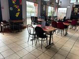 many tables and chairs in this restaurant with a laptop on the table