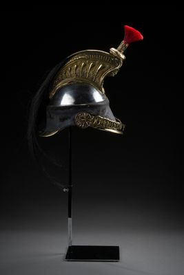 un casque en bronze posé sur un socle, coiffé d'un bonnet rouge