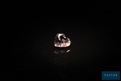 un diamant rose sur une surface noire