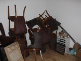 a pile of chairs and boxes in the corner of a room