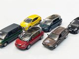 several toy cars are lined up in a row on a white surface