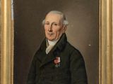 portrait d'un homme vêtu d'un manteau noir, avec une rose à la boutonnière