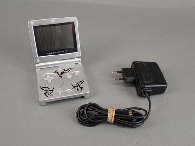 a small game console with a charger and a power cord