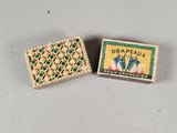 two matchboxes of matchsticks sitting on top of a table