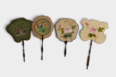 four hand painted mirrors are lined up on a white surface