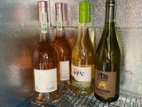 many bottles of wine sitting on a shelf in a refrigerator