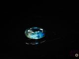 un gros plan d'un cristal bleu sur une surface noire