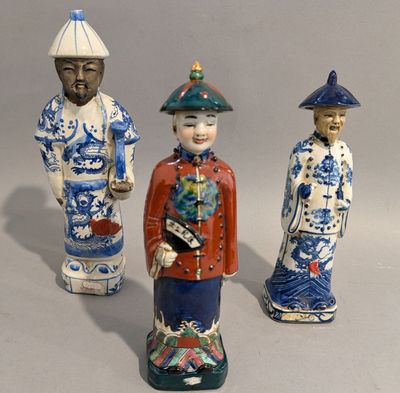 trois figurines représentant des hommes asiatiques debout les uns à côté des autres