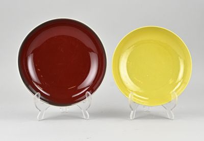 deux assiettes jaunes et rouges posées côte à côte sur une surface blanche