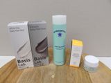 a bottle of lotion, a tube of lotion, and a tube of lotion on a table