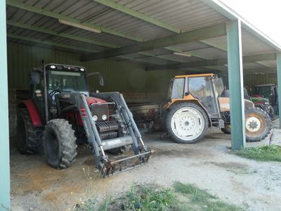 deux tracteurs garés dans un garage, l'un derrière l'autre