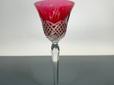 un gobelet en verre rouge posé sur une table, sur fond blanc