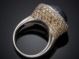 a close up of a ring with a stone in it on a black surface