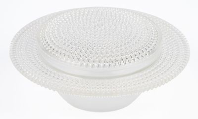 a white plate with a plastic lid on a white table