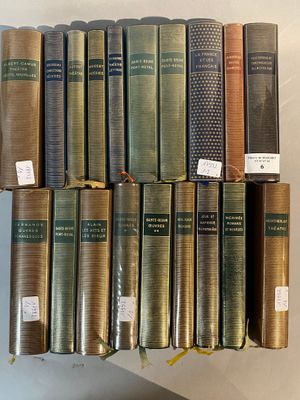 several books are stacked on top of each other on a shelf