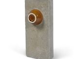 un parpaing orné d'un bouton marron sur fond blanc