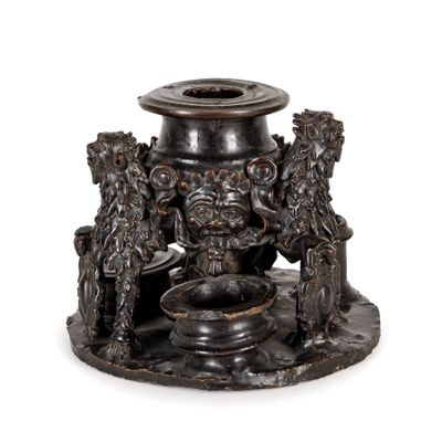 a black candle holder that has a lion and a lion head on it