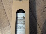 une bouteille de vin dans une boîte en carton posée par terre