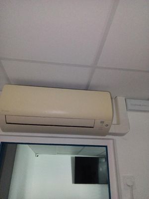 un climatiseur fixé au plafond au-dessus d'une fenêtre