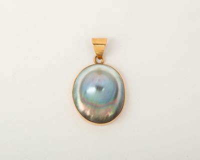 un pendentif en or orné d'une perle noire sur fond blanc