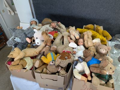 de nombreuses peluches posées dans une boîte sur une table
