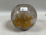 un vase en verre orné d'un dragon doré