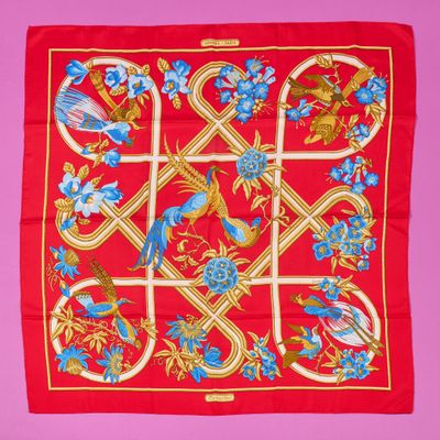 a red scarf with blue flowers and birds on it